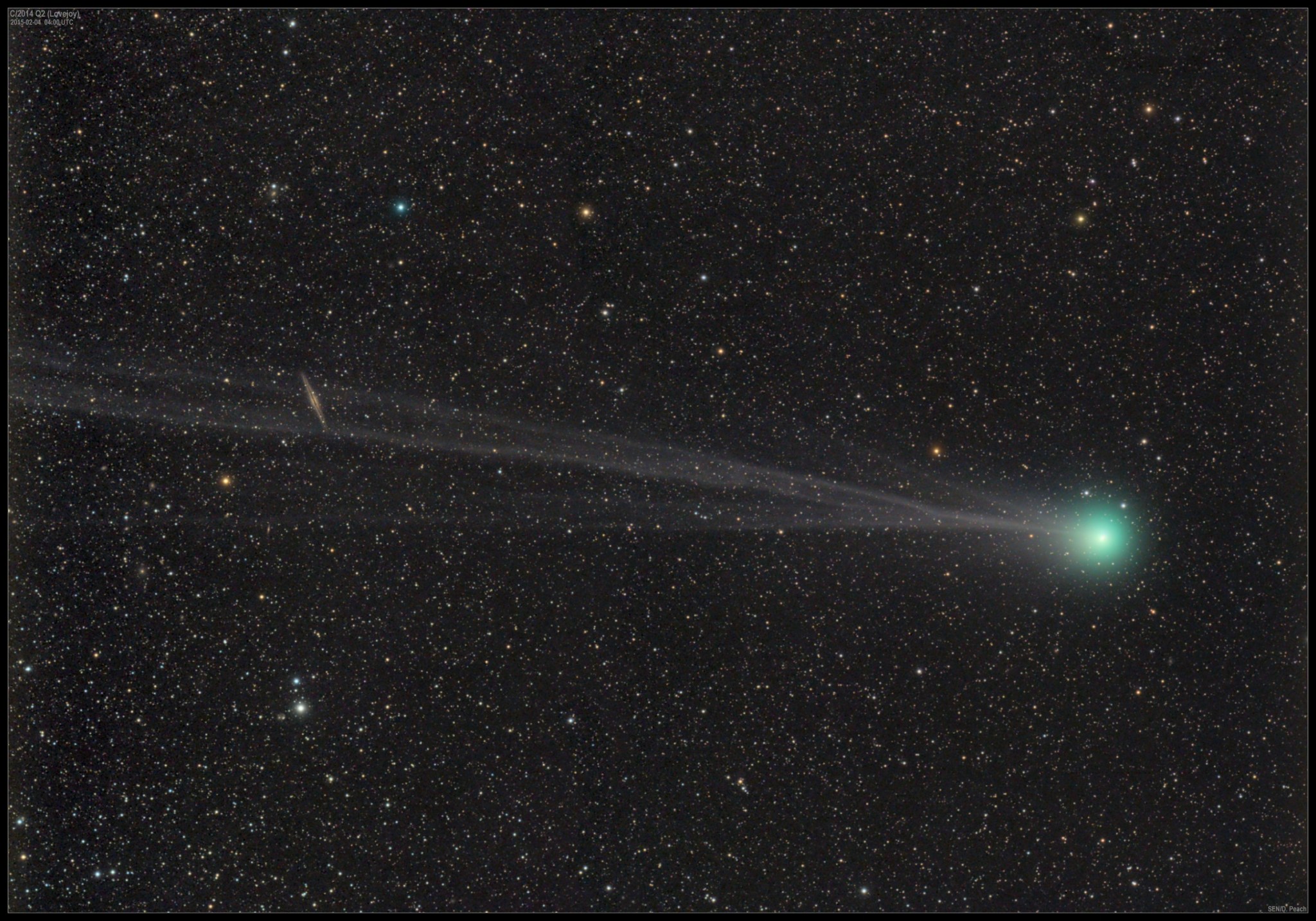 greenish comet against stars with galaxy in tail