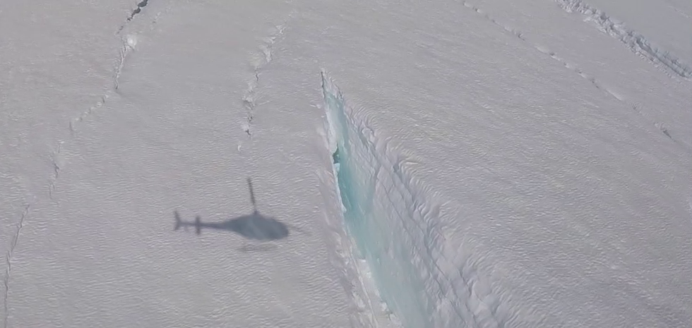 shadow of helicopter near a crevasse in ice