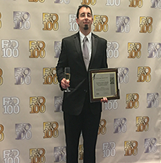 Dr. Wohl posing with a 2016 R&D 100 Award won by one of the coating technologies. 