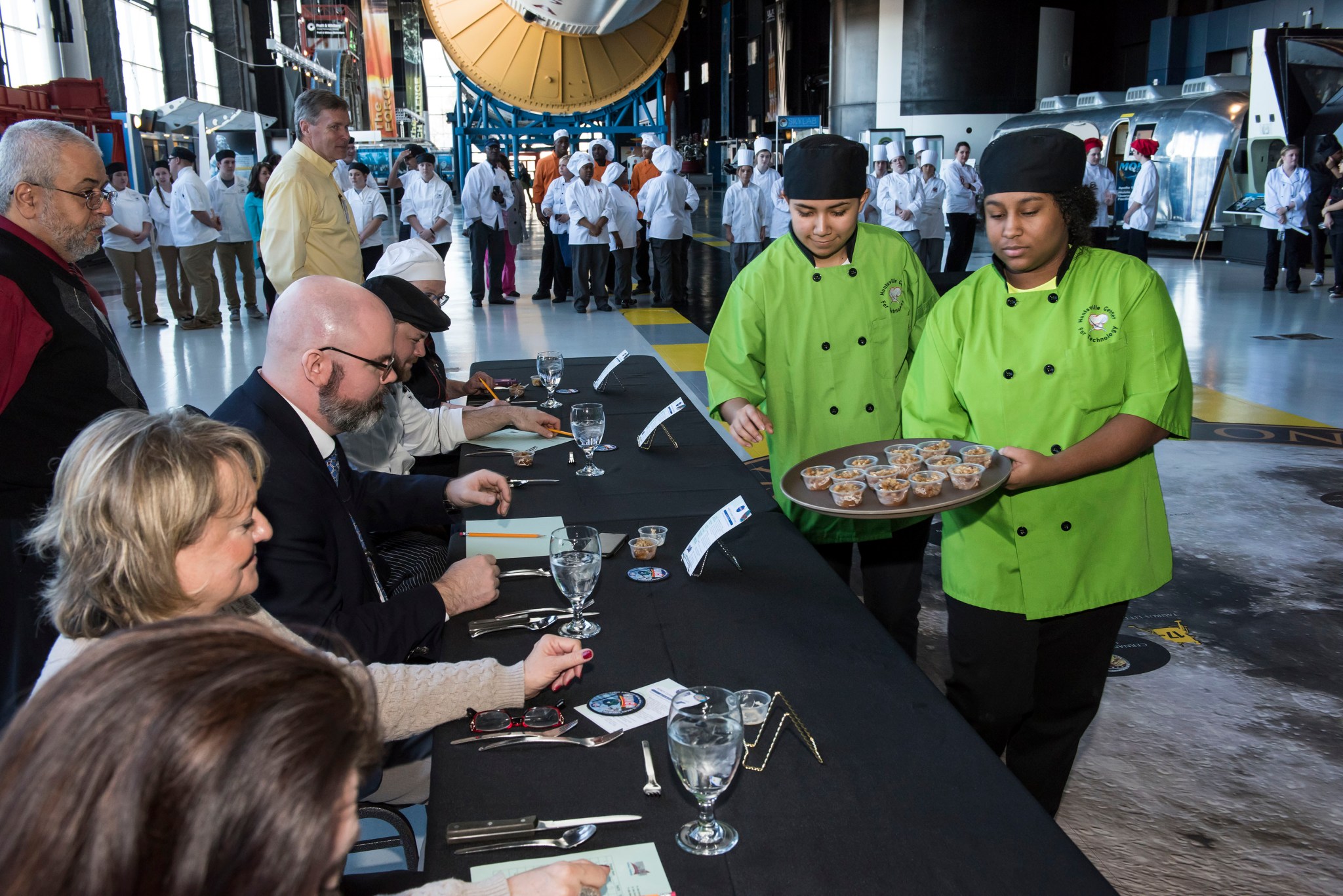 Students from the Huntsville Center for Technology provide servings of their entry into the culinary competition to judges.