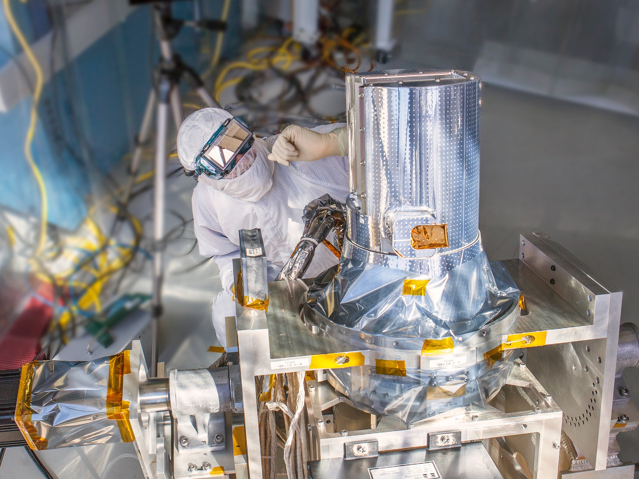 person in protective gear near shiny technology