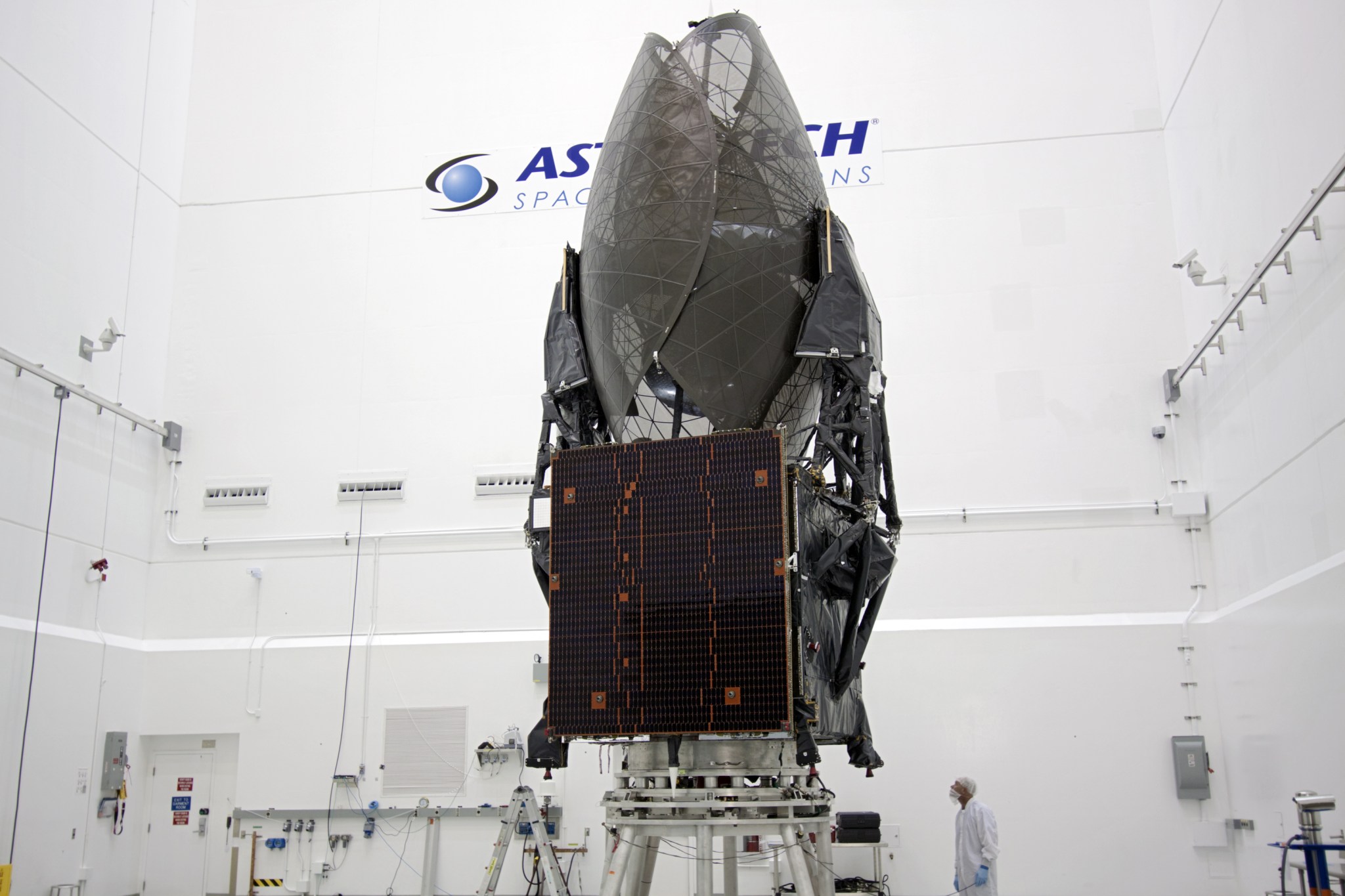 TDRS-K spacecraft stands inside a processing hangar 