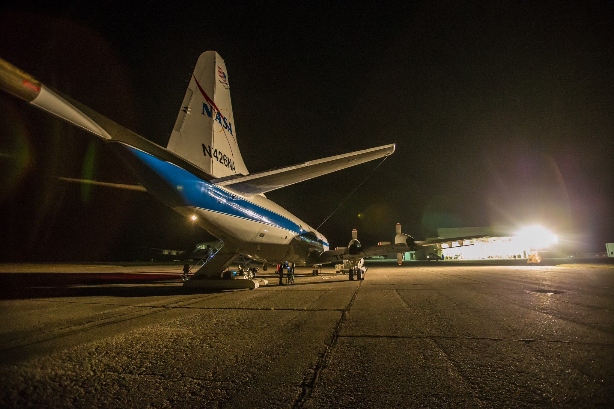 The back end of the P-3 airplane with a hangar in the background.