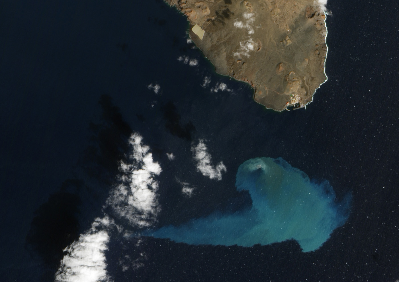 satellite view of peninsula with blue smudge in ocean
