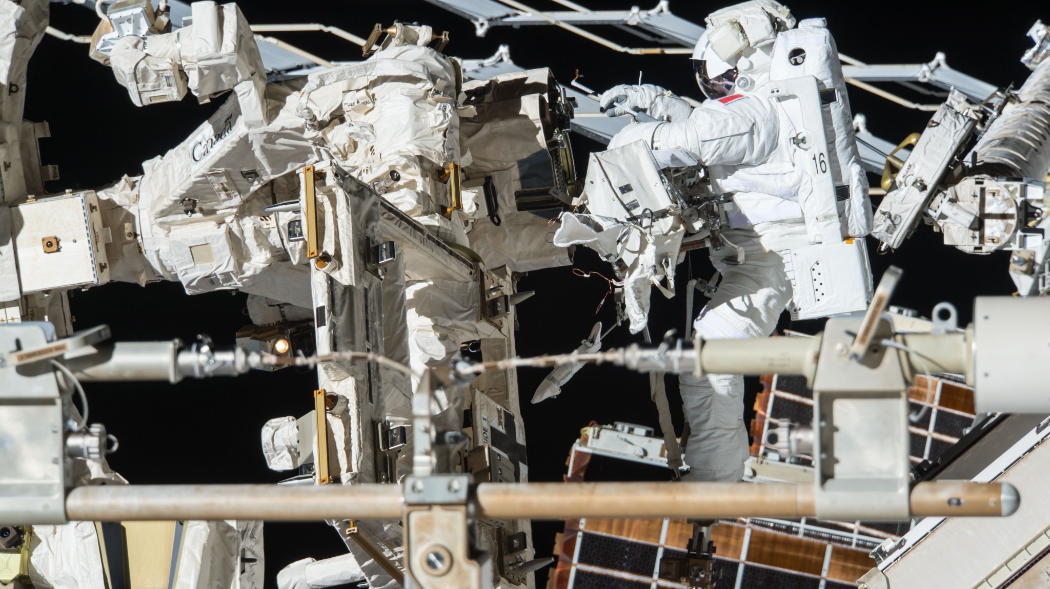 European Space Agency astronaut Thomas Pesquet works on the Canadarm2 during a spacewalk outside the International Space Station