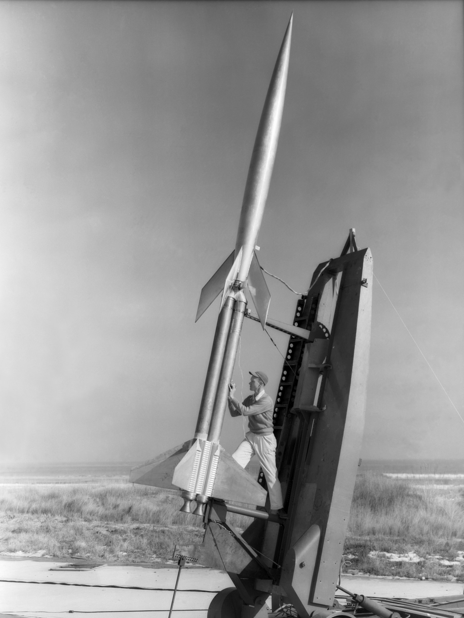 RM-10 Research Model on Launcher Wallops Island NASA Langley. Technician Durwood Dereng measures elevation of double Deacon booster prior to launch of RM-10 research model at Wallops, February 6, 1951. Photograph published in A New Dimension; Wallops Island Flight