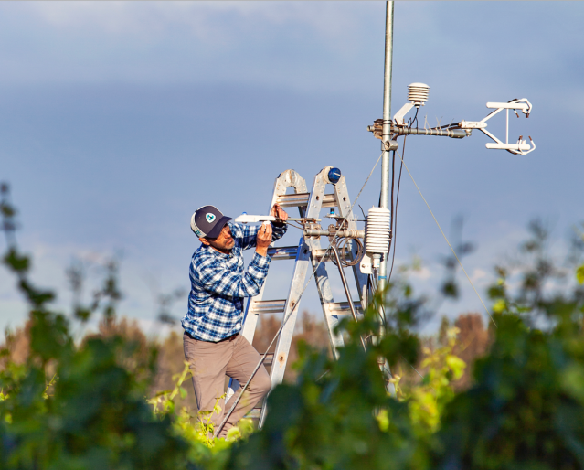 Forrest Melton fixes an instrument in the field as part of OpenET.