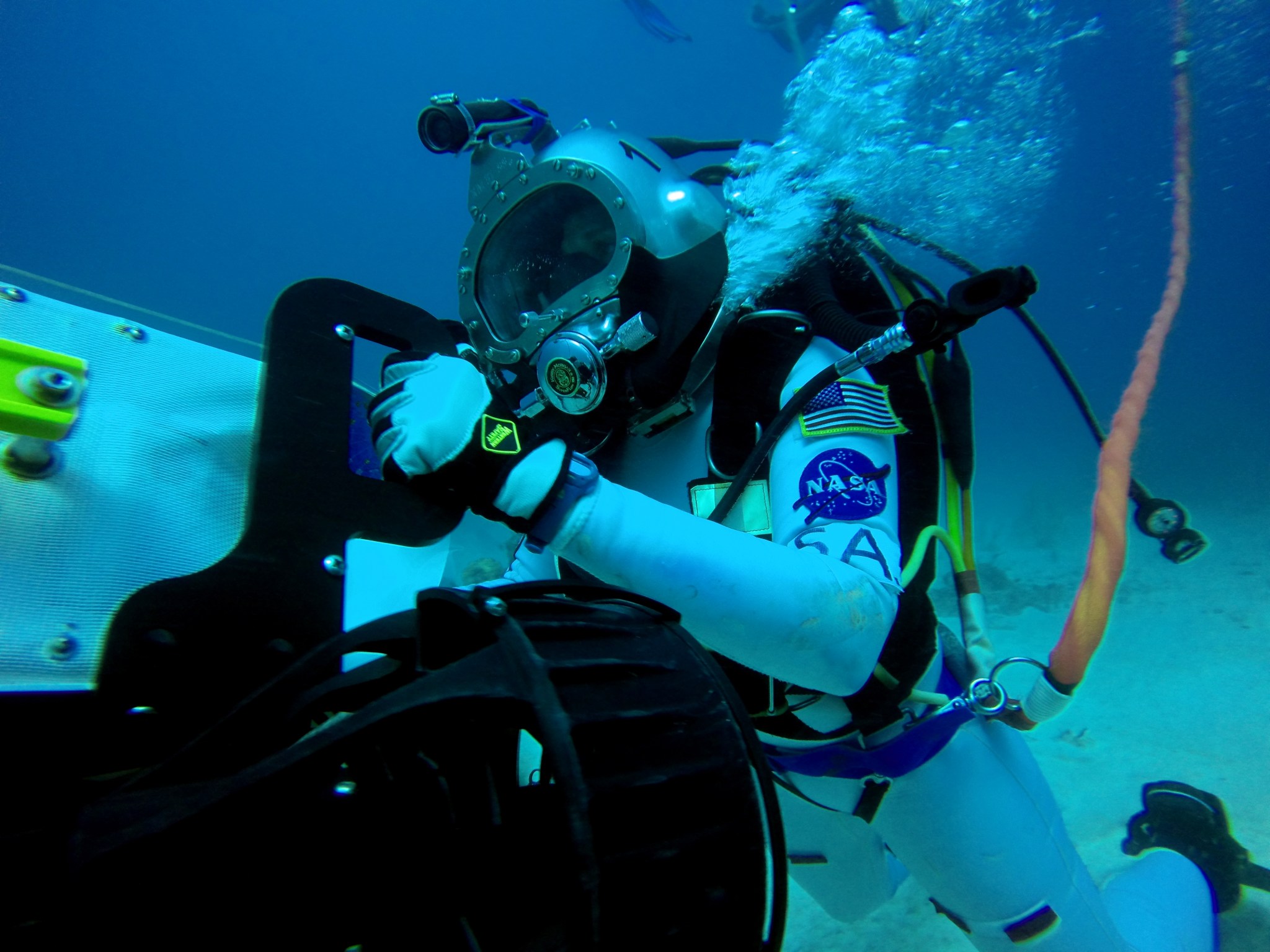 Astronaut Serena Aunon moving tools and equipment underwater. 