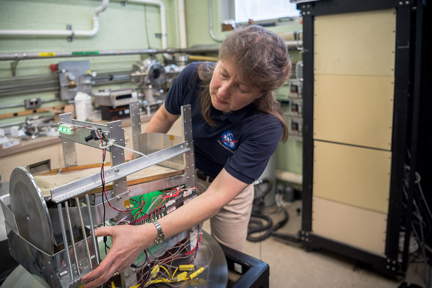 Diane Linne stands in a lab adjusting equipment she uses to advance in-situ resource utilization technology at NASA Glenn