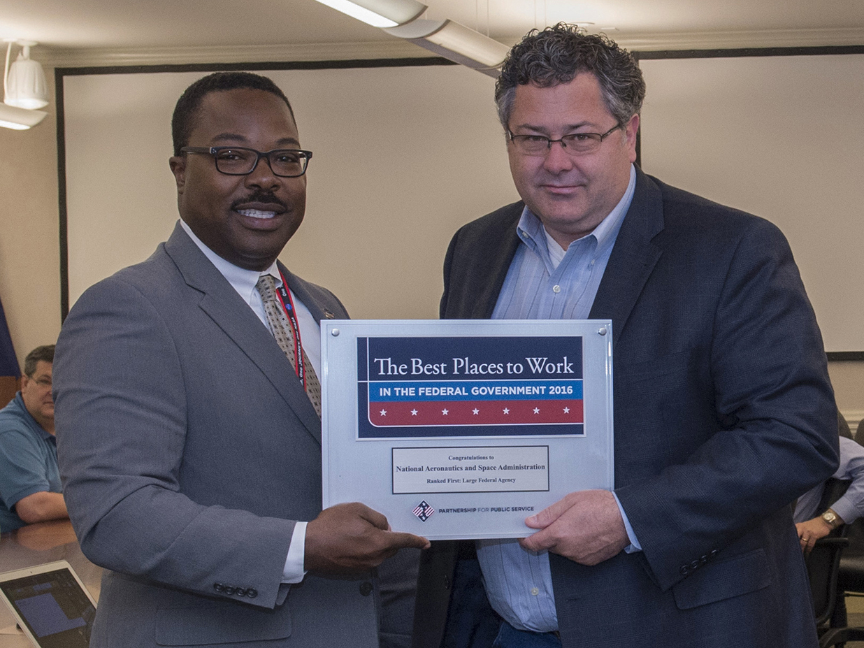 Todd May, right, director of NASA’s Marshall Space Flight Center, is presented a commemorative plaque by Marcus Lea.