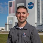A photo of Kennedy Space Center's Matt Czech with the Vehicle Assembly Building in the background.
