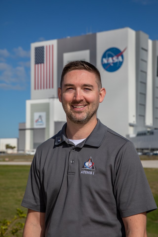 A photo of Kennedy Space Center's Matt Czech with the Vehicle Assembly Building in the background.