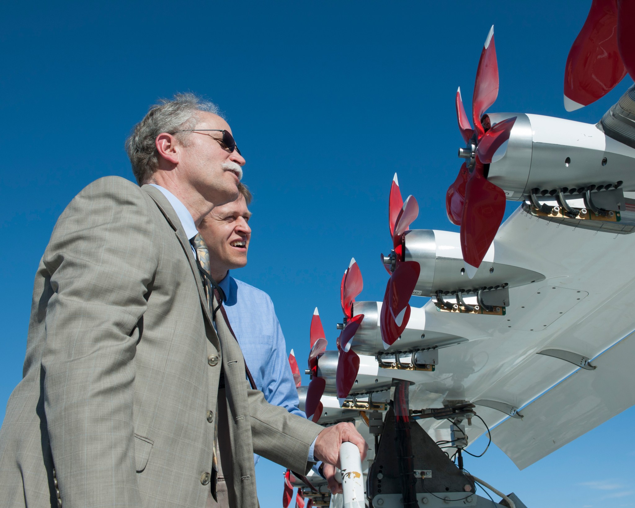 Retiring program director Doug Rohn (l) takes a look at an experimental wing carrying electric motors.