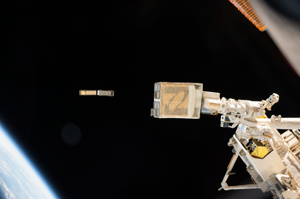 In this photo taken by NASA astronaut Peggy Whitson from inside the International Space Station cupola, the NanoRacks deployer (foreground) is clearly visible as the CXBN-2 and IceCube CubeSats deploy. CSUNSat-1 deployed on time two days later. The three CubeSat payloads make up NASA’s ELaNa 17 mission which launched in April aboard the Orbital ATK Cygnus spacecraft on a commercial resupply flight to the station.