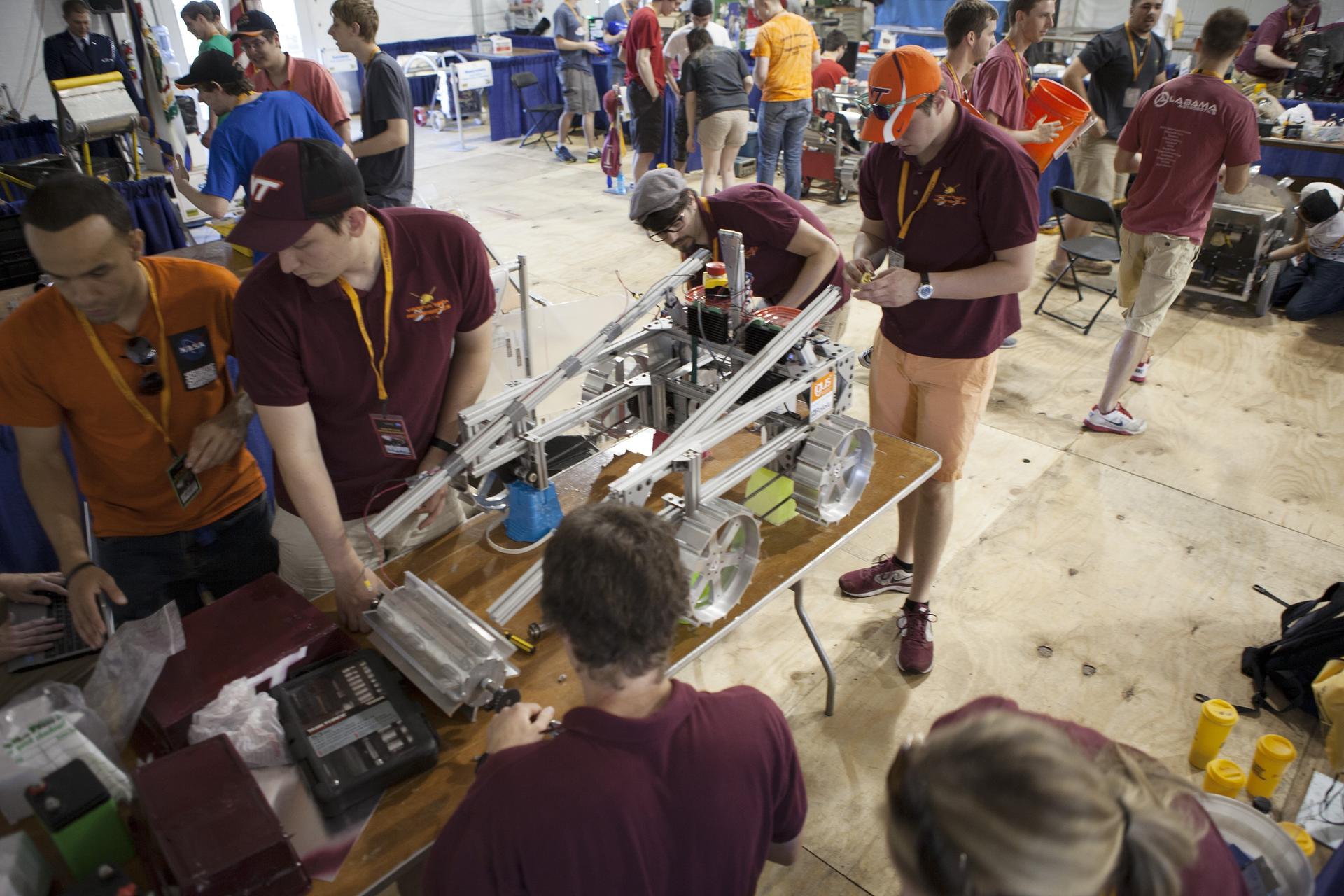 Team members from the University of Alabama prepare their robot during NASA's 2014 Robotics Mining Competition