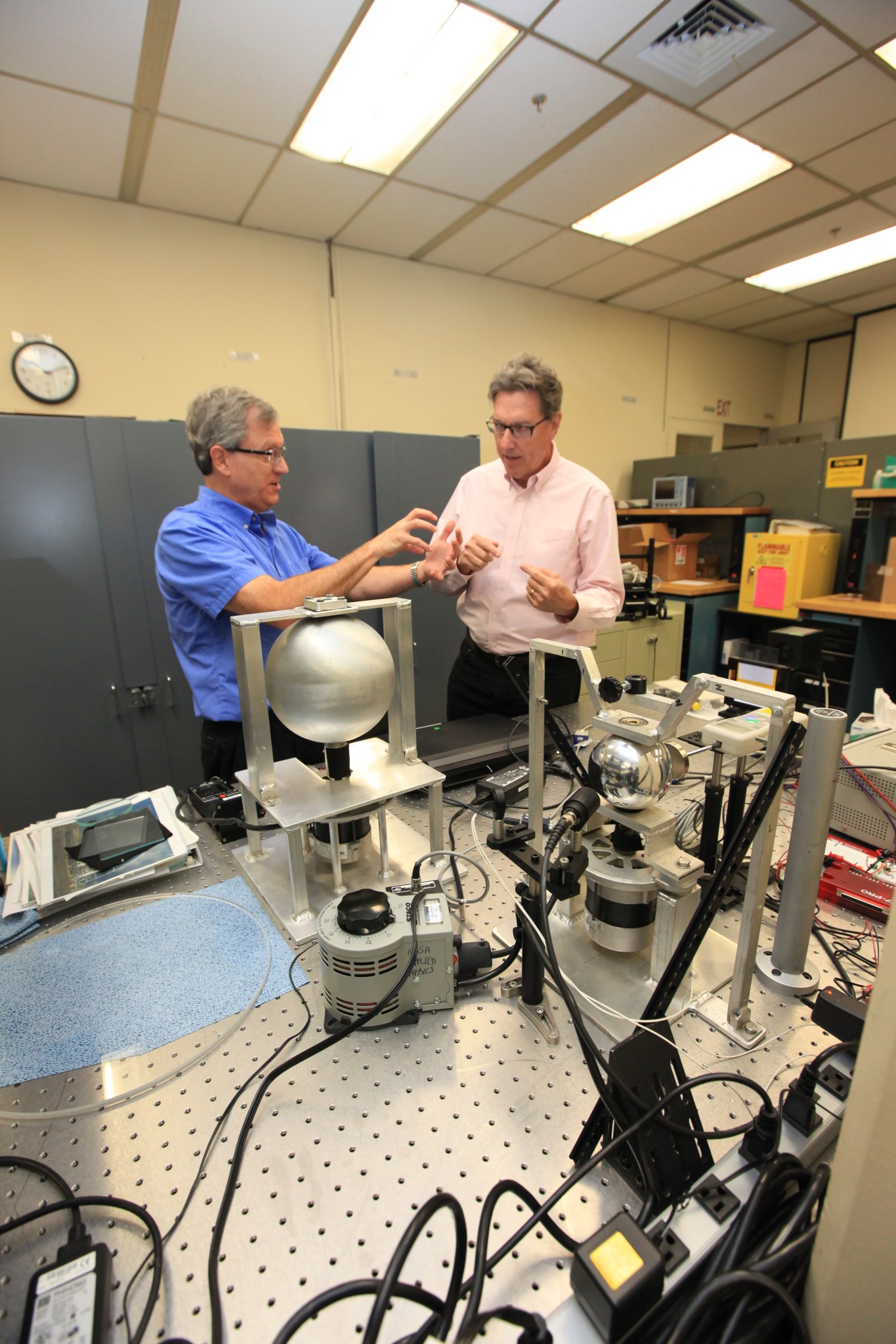 NASA's Stan Starr and Bob Youngquist work with magnetic spheres in lab.