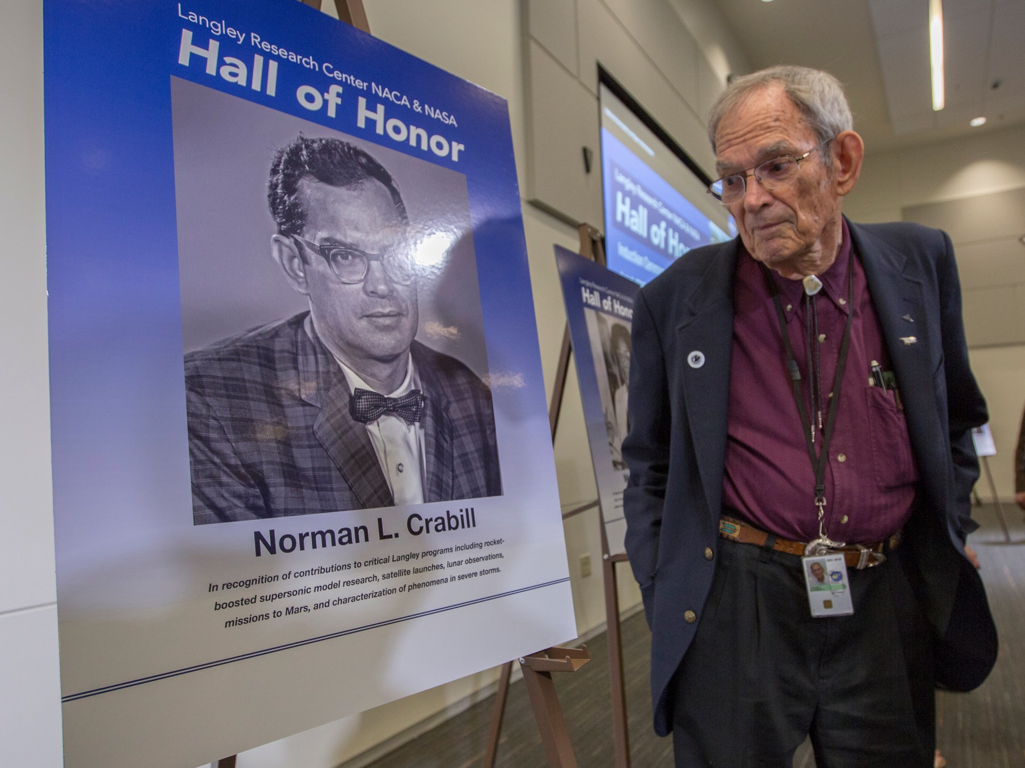 NASA Langley Hall of Honor inductee Norman Crabill looks at a picture of himself after the induction ceremony.