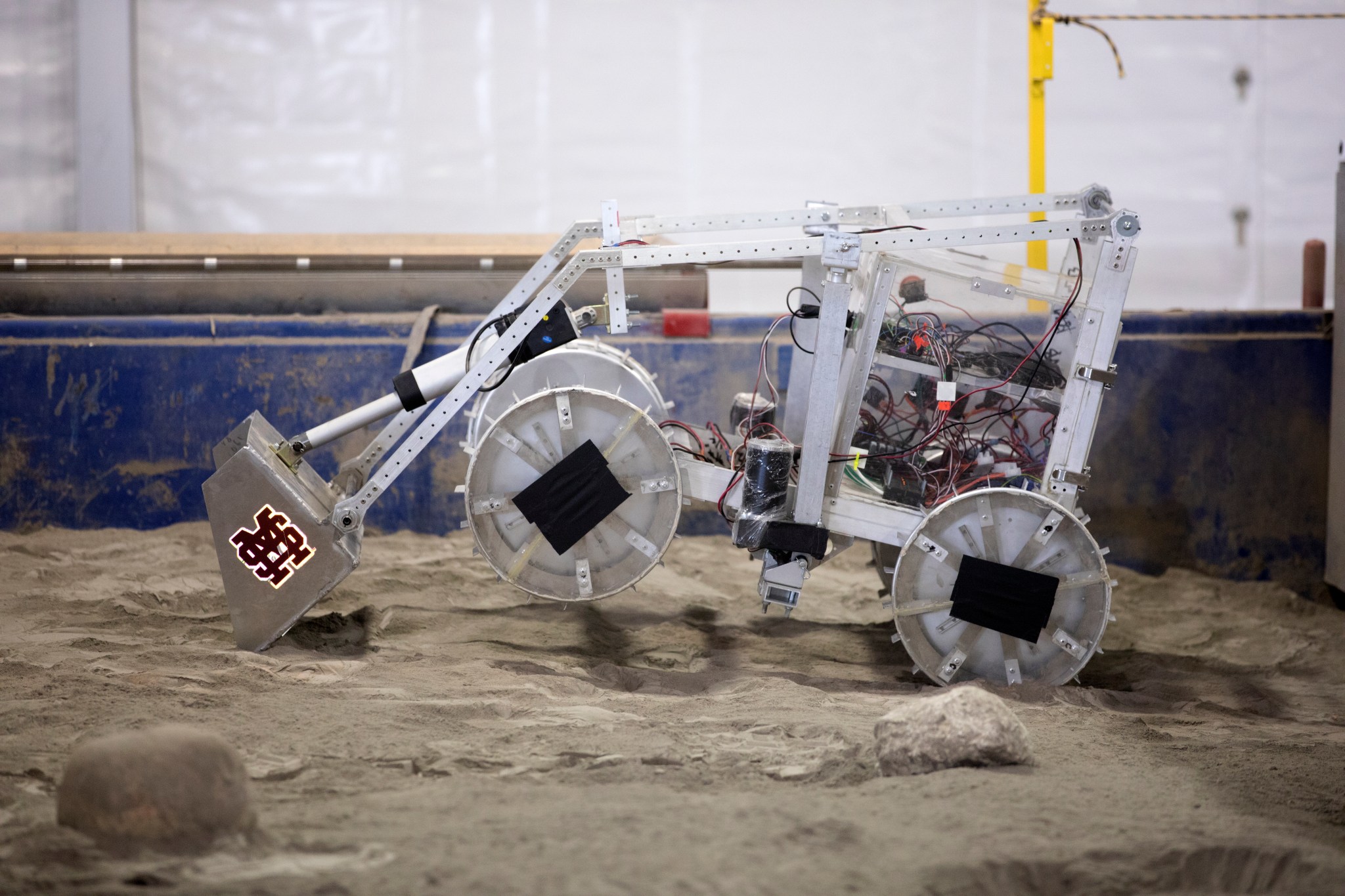 A robot miner traverses the simulated Martian terrain in the Mining Arena.
