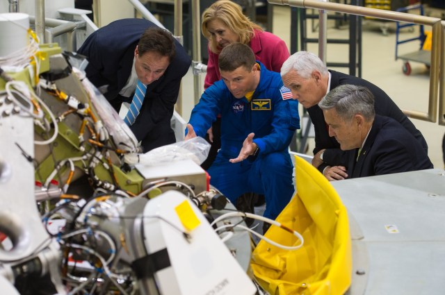 A group of people, including Vice President Mike Pence, look at the Orion capsule during a tour of Kennedy Space Center.