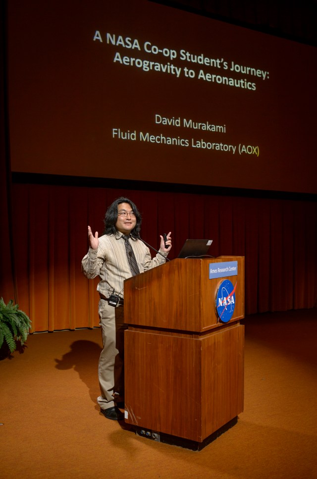 David Murakami standing on stage in front of podium