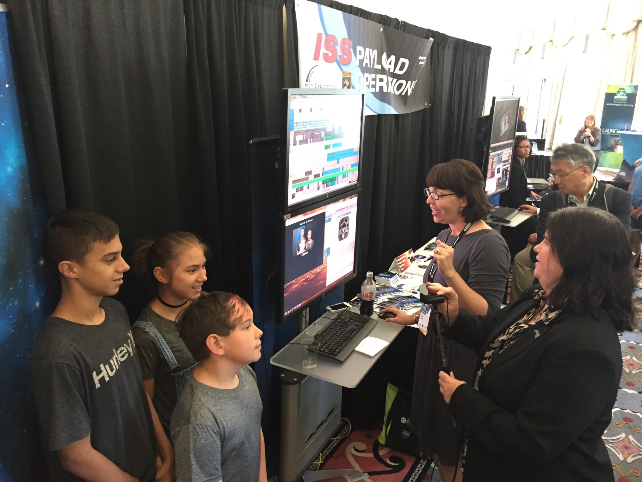 Penny J. Pettigrew, far right, and Gina Wade, both from Marshall, demonstrate how information is transmitted to the space staion