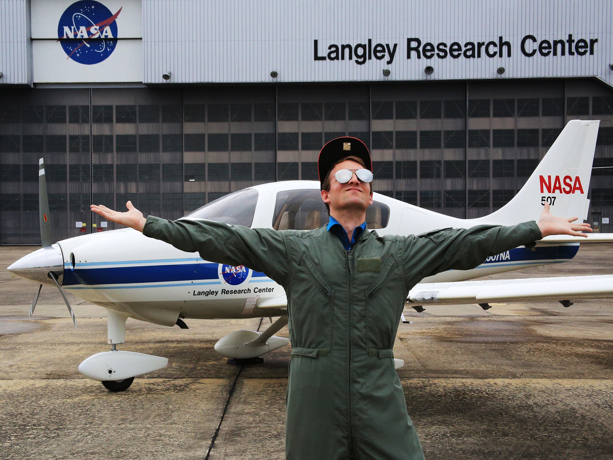 Kenneth Smith is pictured in a flight suit in front of NASA Langley's hangar.
