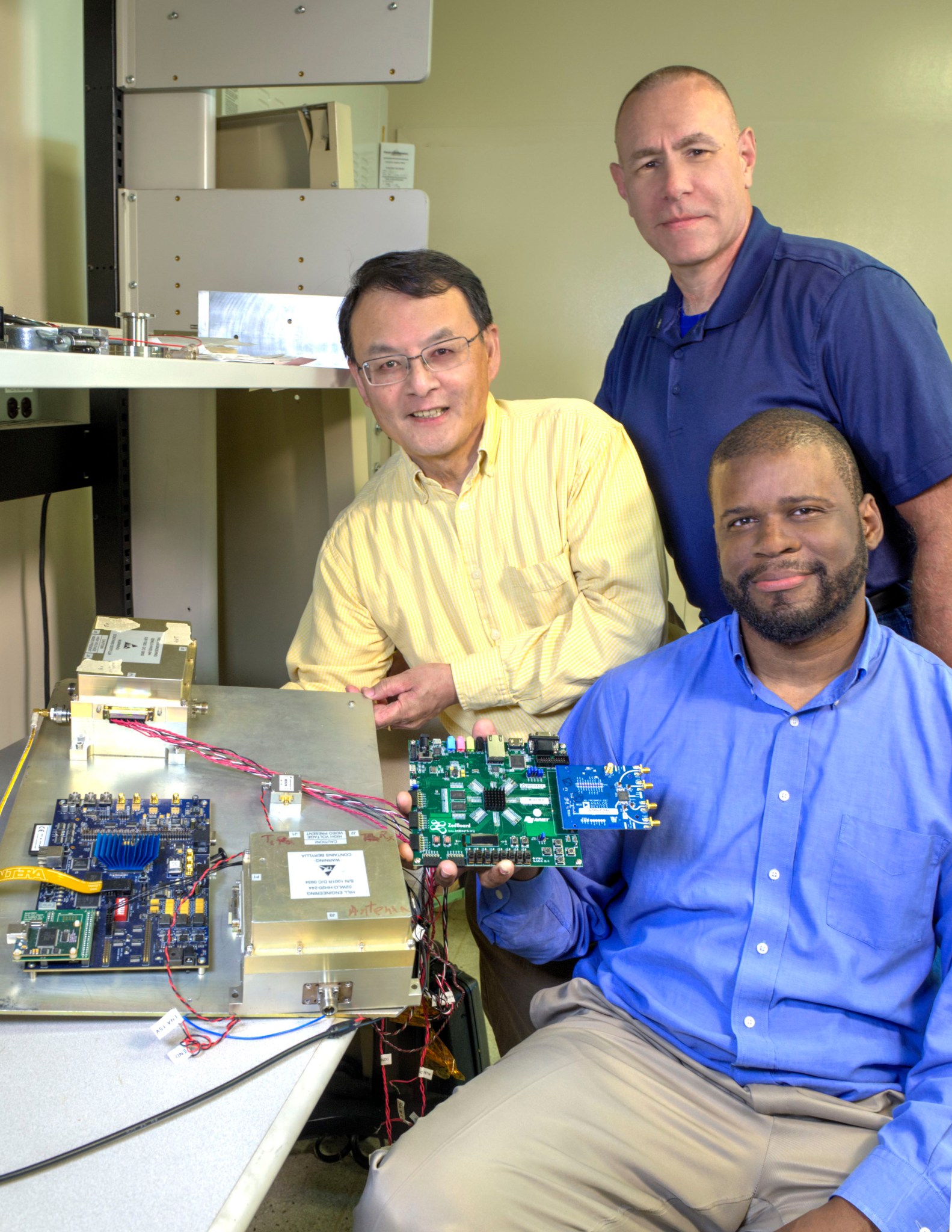 ECHOES team, three men hold parts of technology
