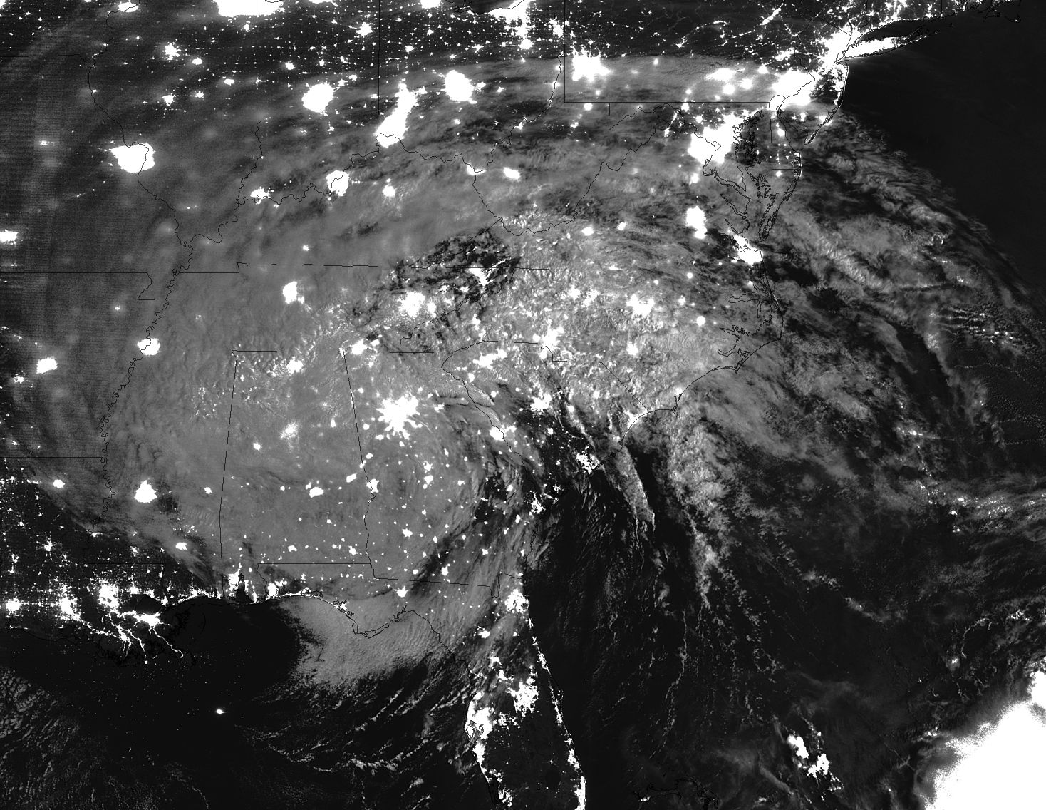Nighttime satellite image of Irma with electric lights visible through the white cloud mass over the southeastern US.