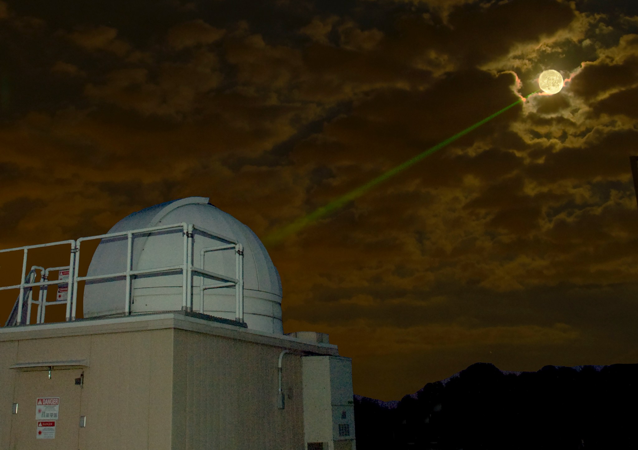 image of building with green laser pointing towards the Moon