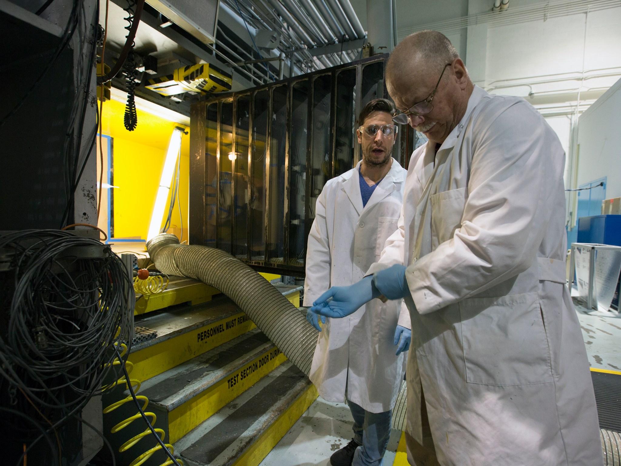 Kyle Goodman, left, is assisting Bill Lipford paint a scaled model of the Space Launch System.
