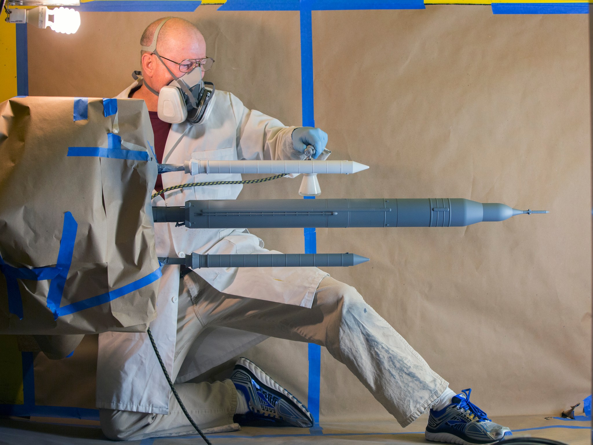 Bill Lipford is painting a scaled model of the Space Launch System at NASA's Langley Research Center.