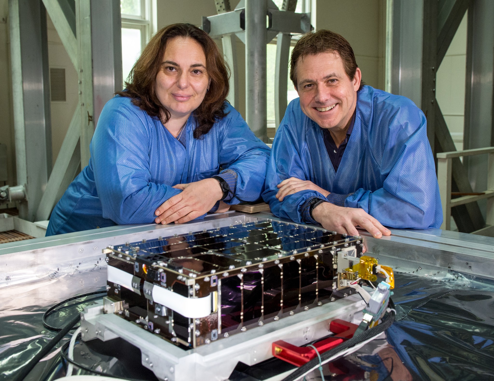 Principal Investigators Eftyhia Zesta and Todd Bonalsky standing in blue lab coats by technology 