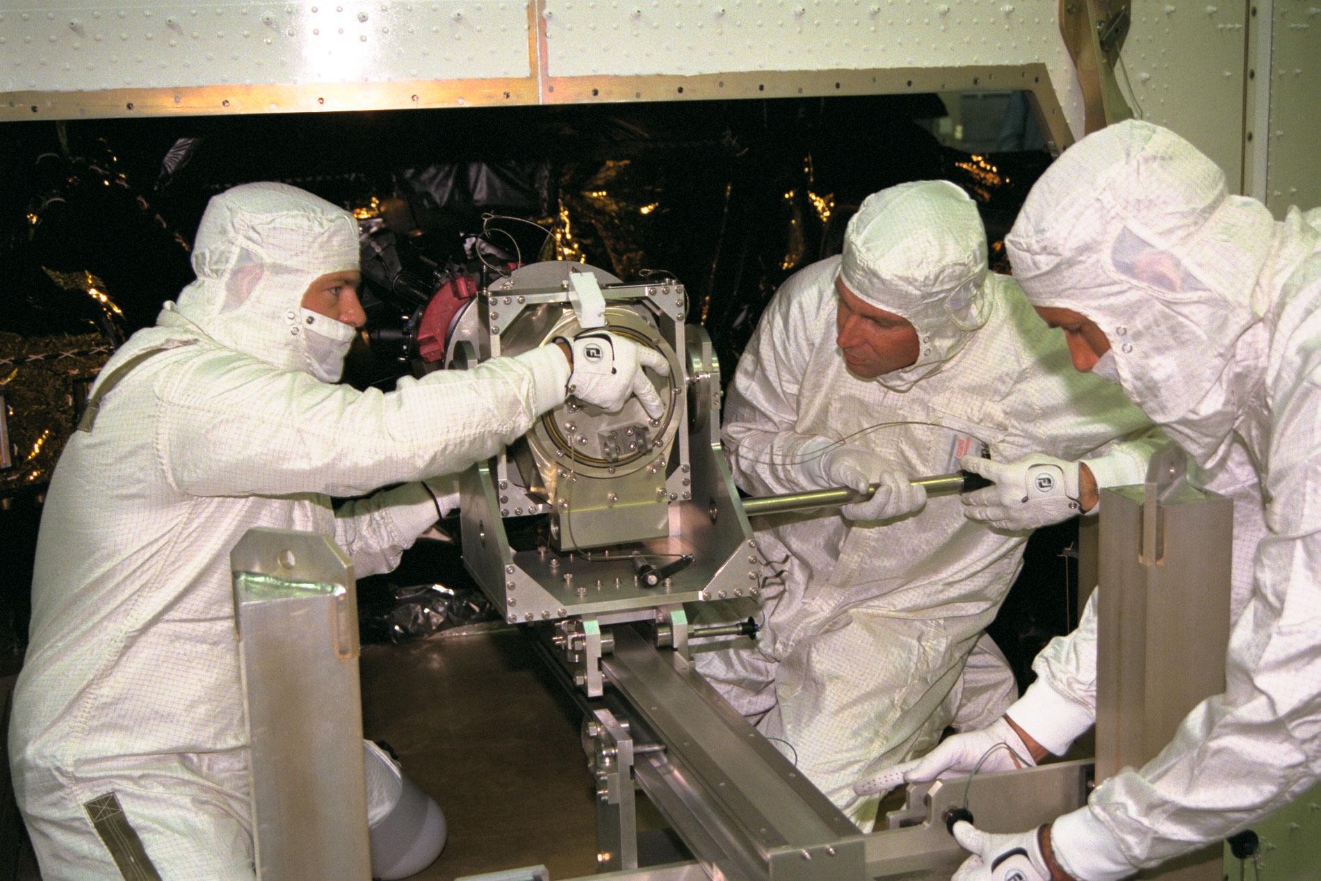 Workers install three radioisotope thermoelectric generators on the Cassini spacecraft Oct. 10, 1997. 