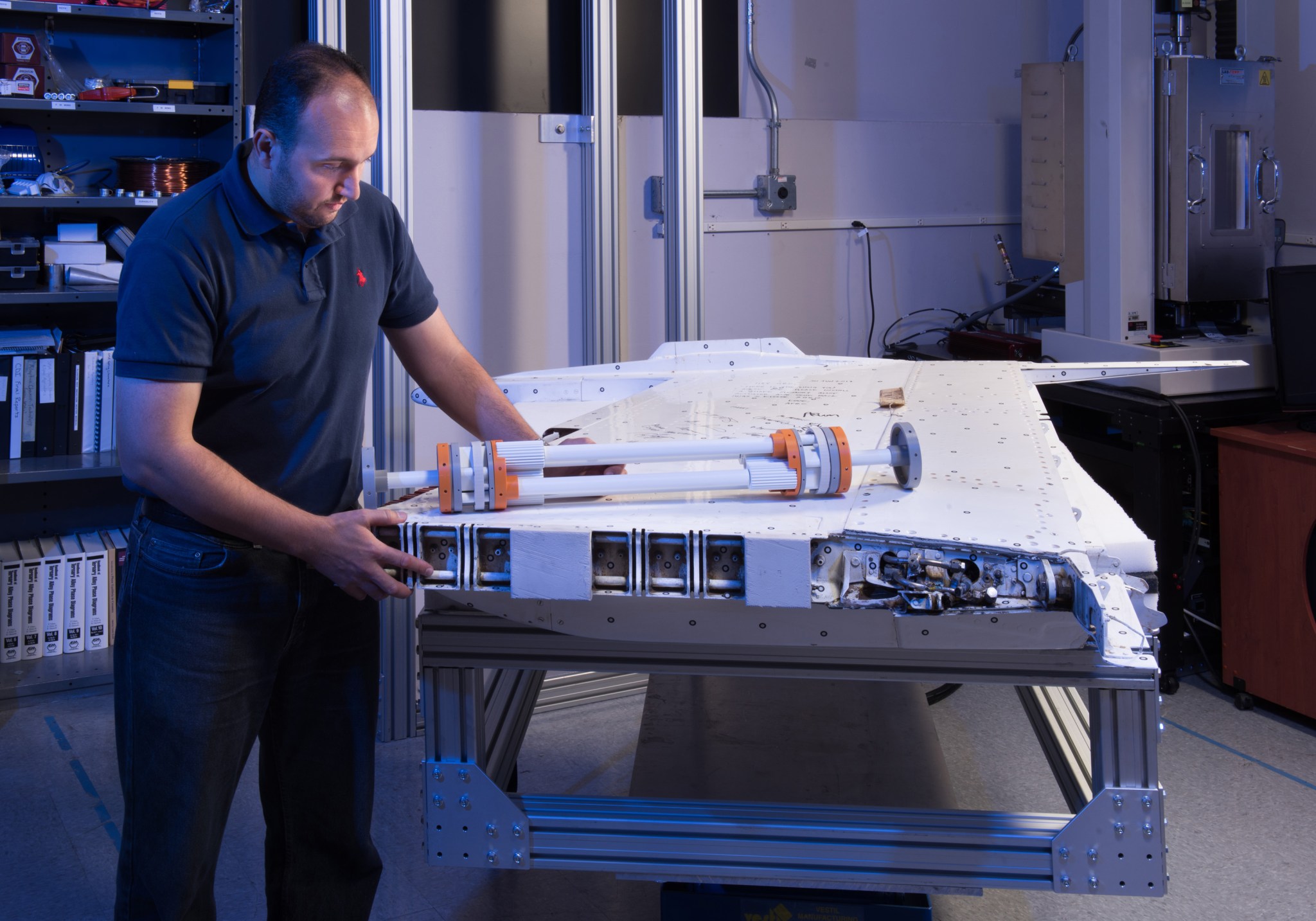 Dr. Othmane Benafan standing next to a model of the shape memory alloy actuator