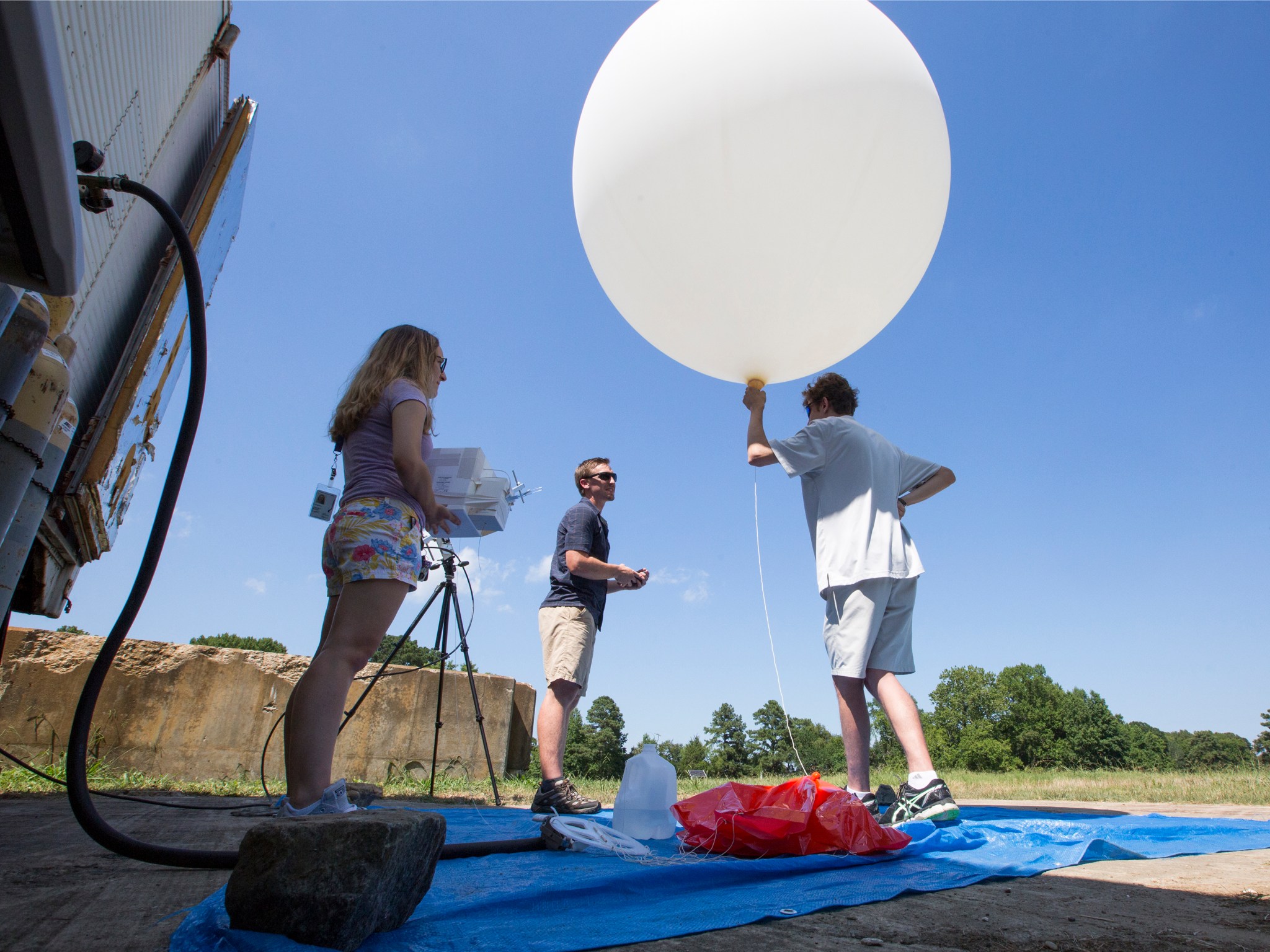 NASA Goddard post-doctoral fellow John Sullivan, along with Lindsey Rodio and Lance Nino, prepare to launch a balloon.
