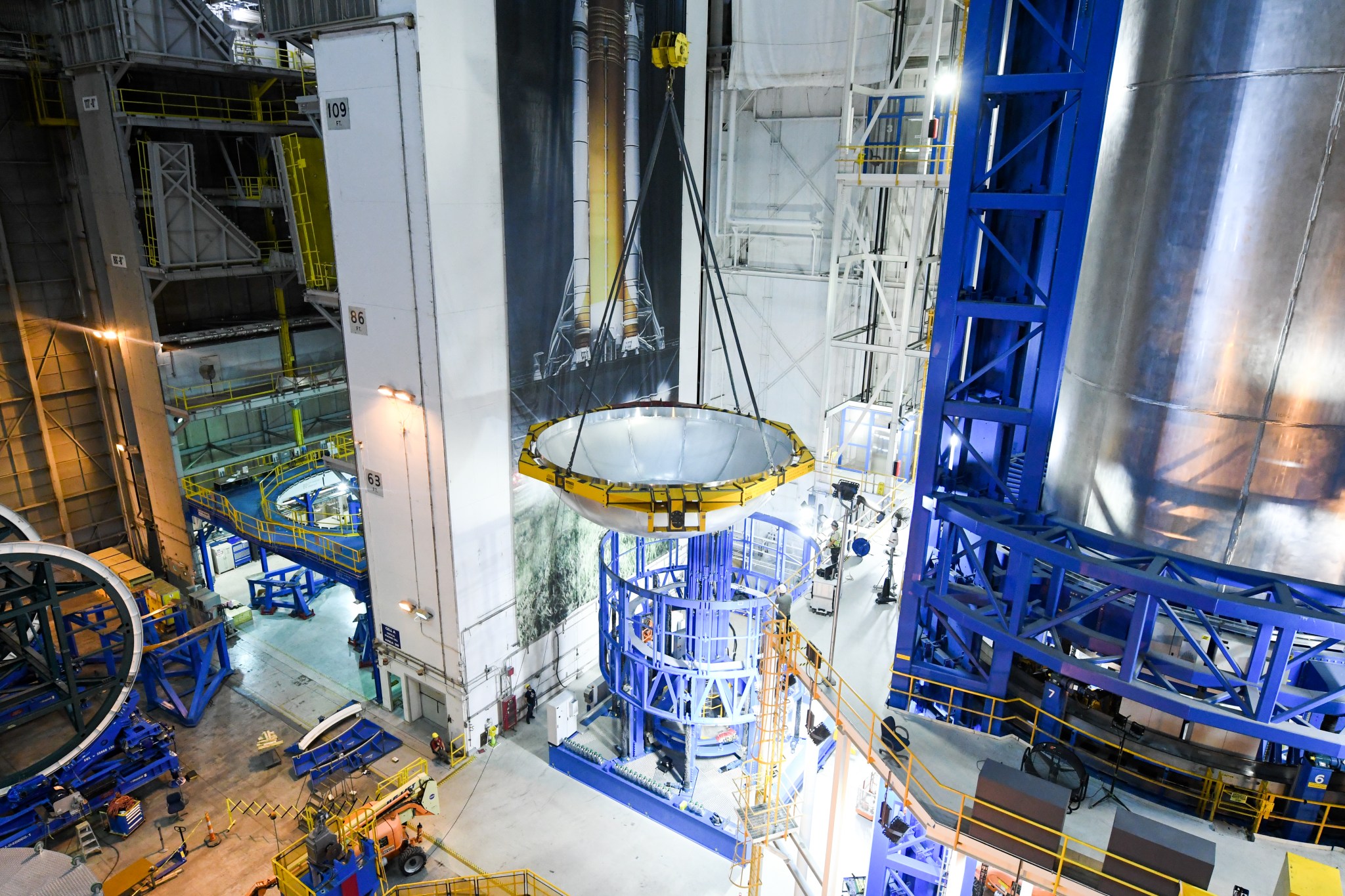 A dome is lifted into place to form the Space Launch System (SLS) liquid hydrogen tank for the first SLS flight. 