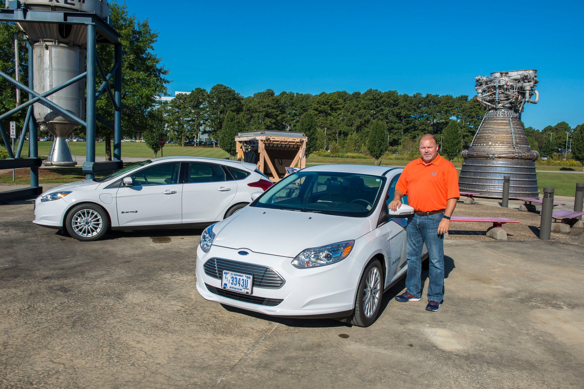 David Norris, Marshall transportation specialist, stands alongside two new, fully electric cars.