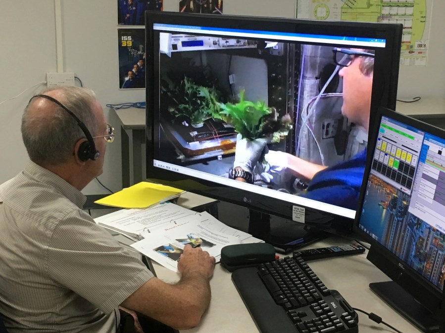 Charles Spern, Engineering Services Contract, communicates instructions for the Veggie system.