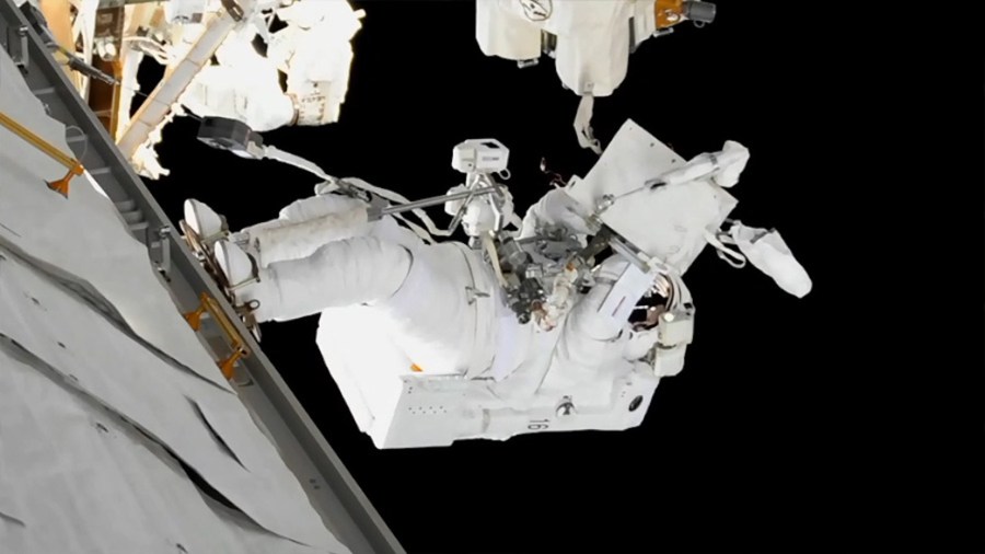 Astronaut in spacesuit at work outside space station module