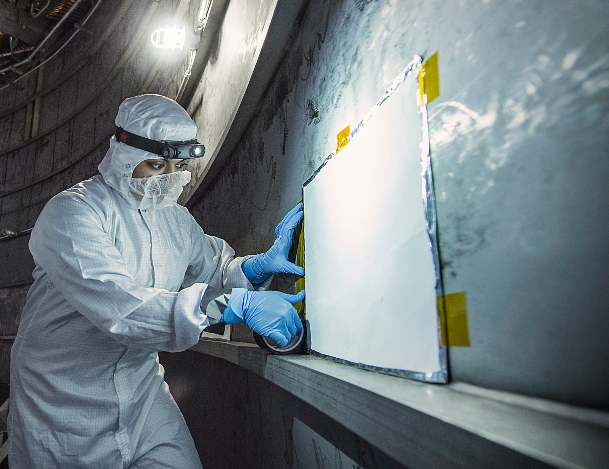 Coatings engineer Nithin Abraham places a molecular adsorber coating (MAC) panel in the plenum of Chamber A at NASA’s Johnson Sp