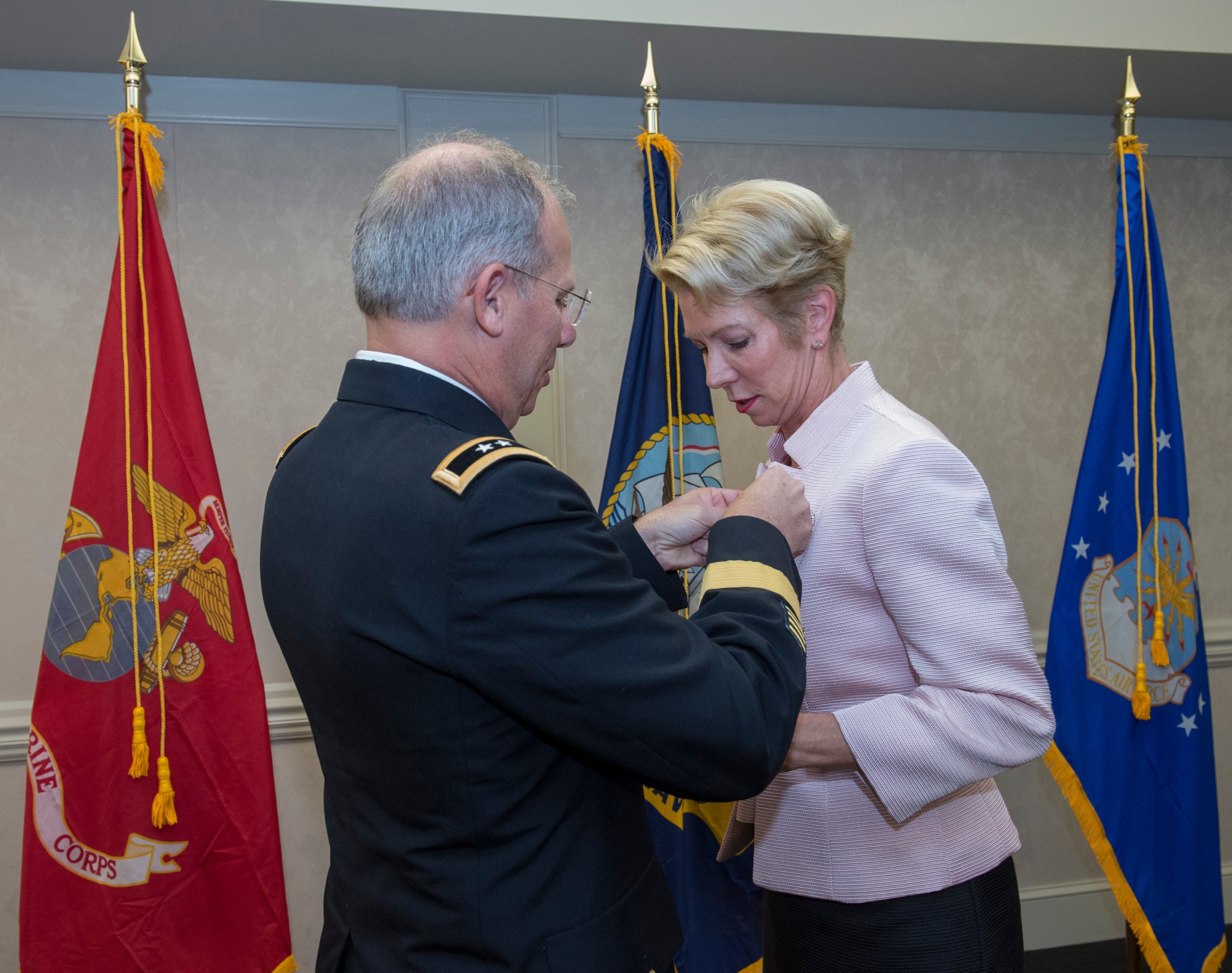 Carole Valenti, right, receives a pin commemorating her military service from Maj. Gen. Allan Elliott.