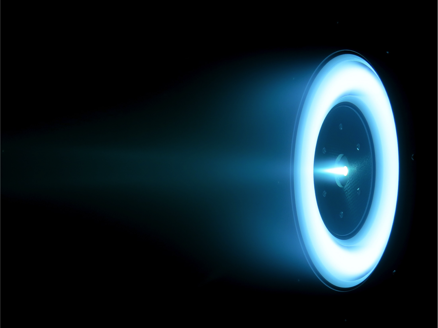 Image of a echnology Development Unit (TDU)-2 thruster is in steady-state operation at 12.5 kW, with environmental tests ongoing