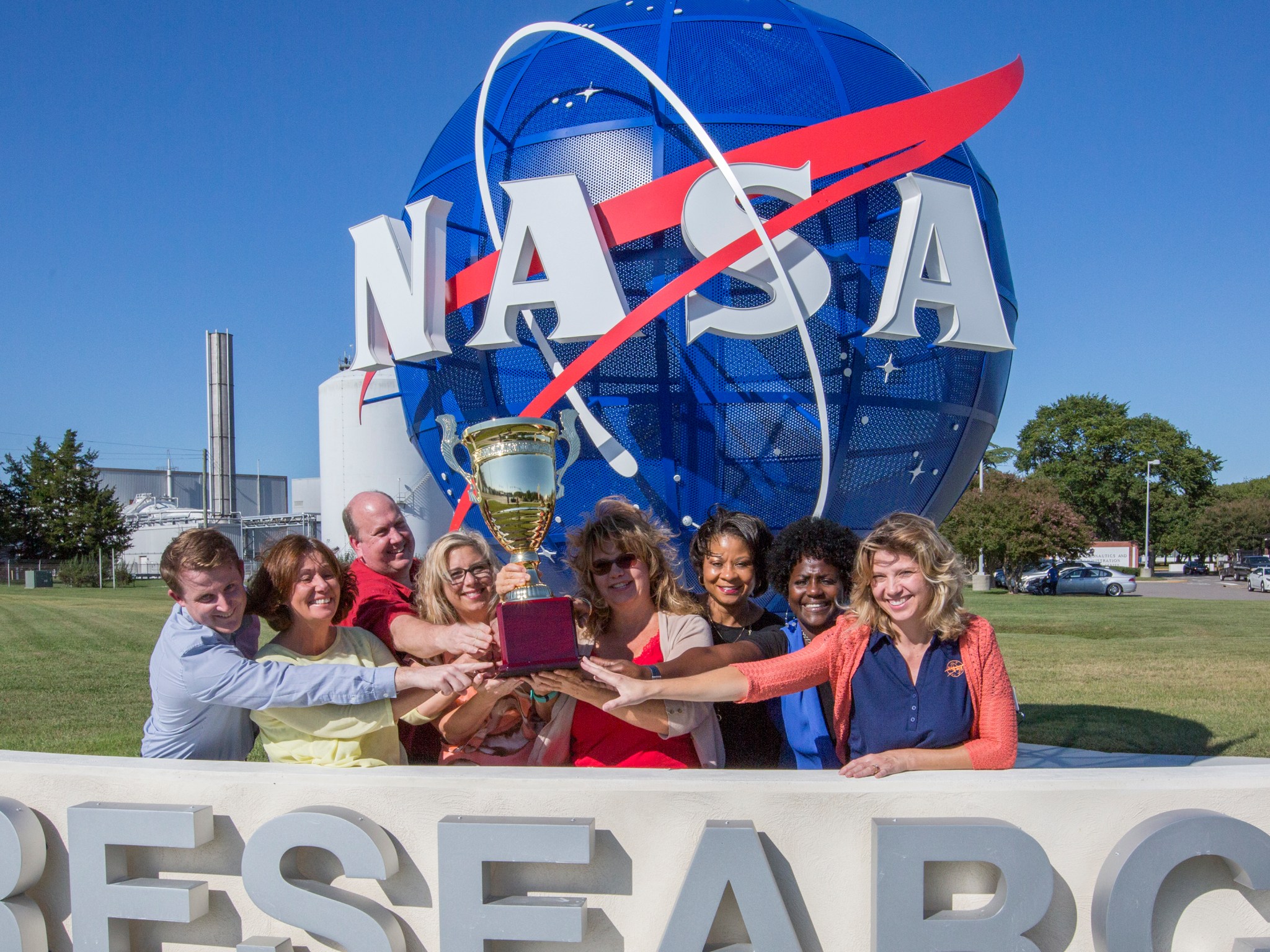 Members of NASA Langley's Technology Transfer Program team pose outside the center with a trophy for their accomplishments.