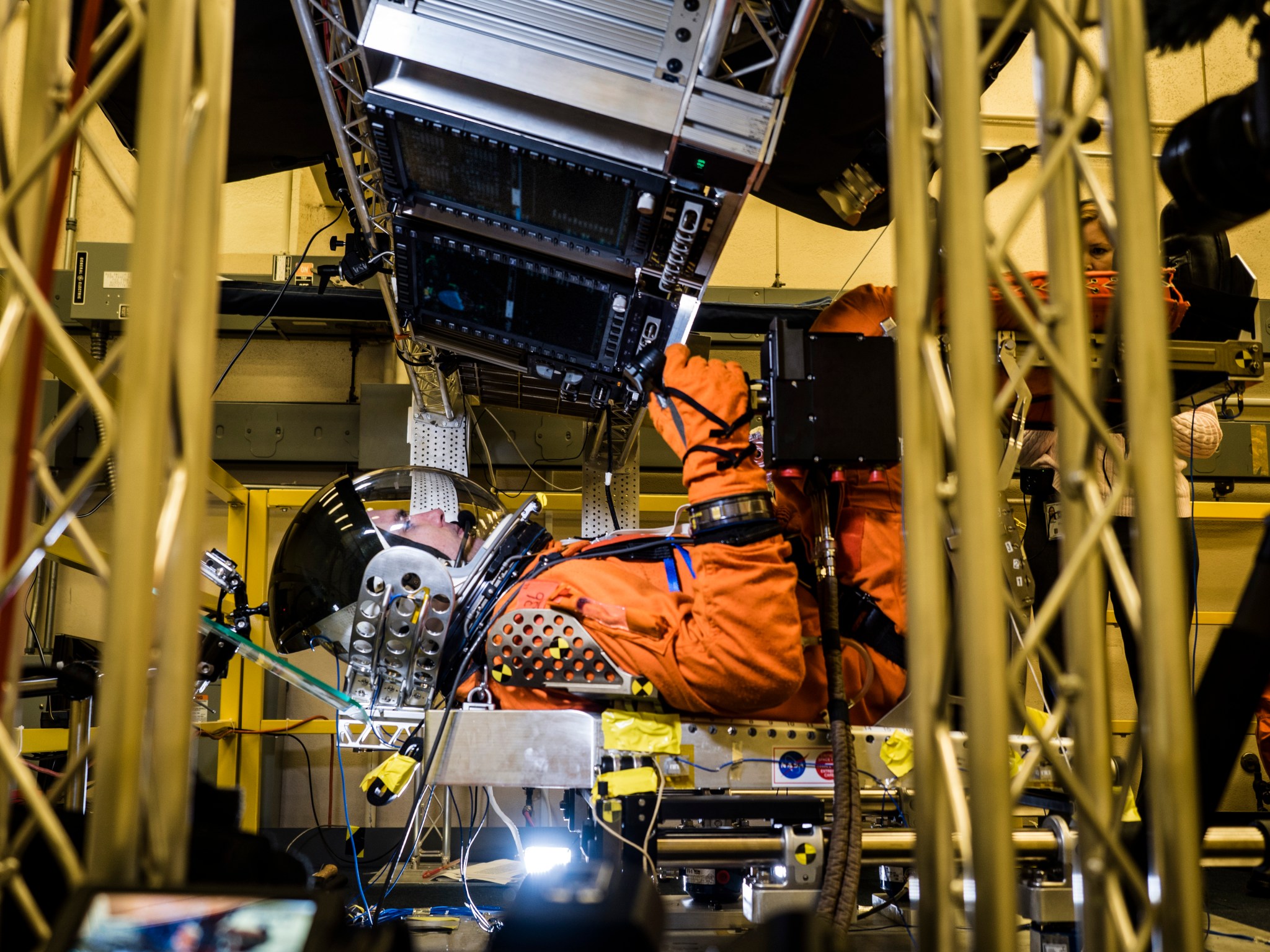 Test subject in crew escape suit seated inside test module