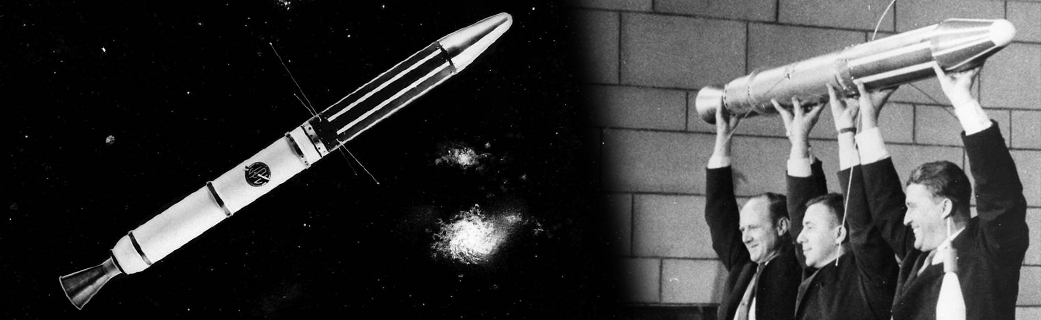 A black-and-white composite image with a model of the Explorer 1 spacecraft on the left, and a photo of three men holding the model on the right. The spacecraft is a classic long, slim, pencil-shaped rocket with a single conical engine at the back and slim antenna-like projections sticking out horizontally from the middle of the rocket. In the image on the left, it is posed in front of a stylized background depicting stars and galaxies. In the photo on the right, three men in suits smile broadly while holding the model over their heads. It takes all three to hold it up.
