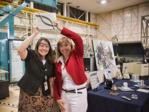 Two women hold up an example of output from an electron beam 3D printer.