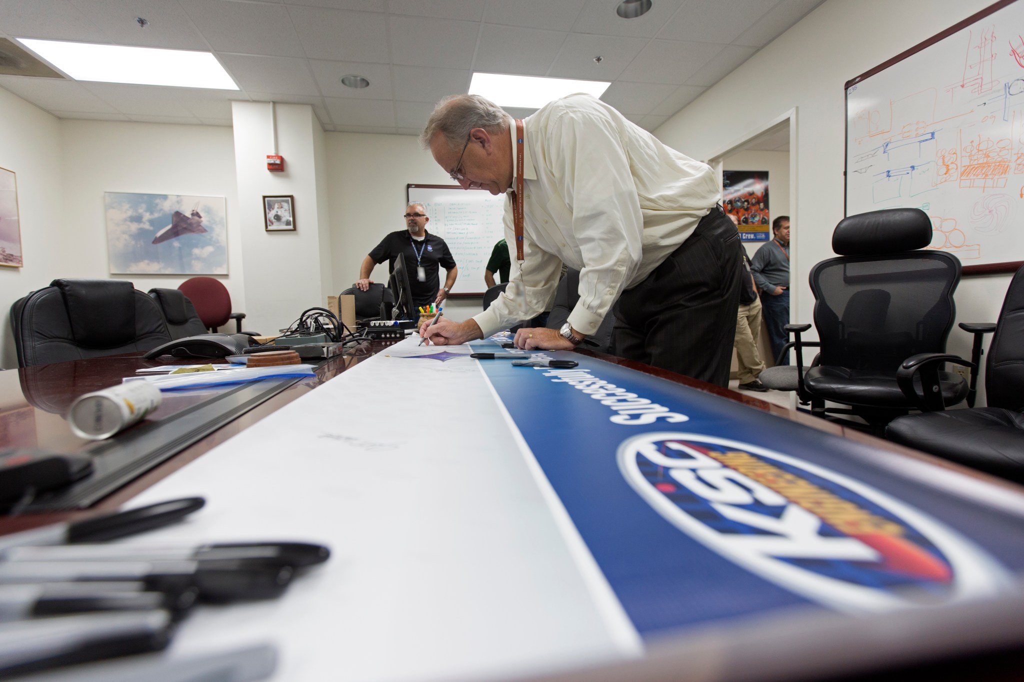 Engineering Director Pat Simpkins signs a banner in the Prototype Development Lab at NASA's Kennedy Space Center in Florida.