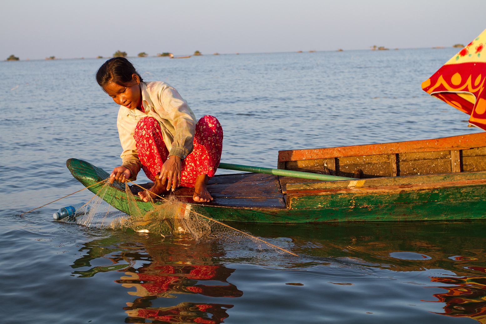 A person fishing at sunset on Tonlé Sap Lake, near Akal village in Cambodia