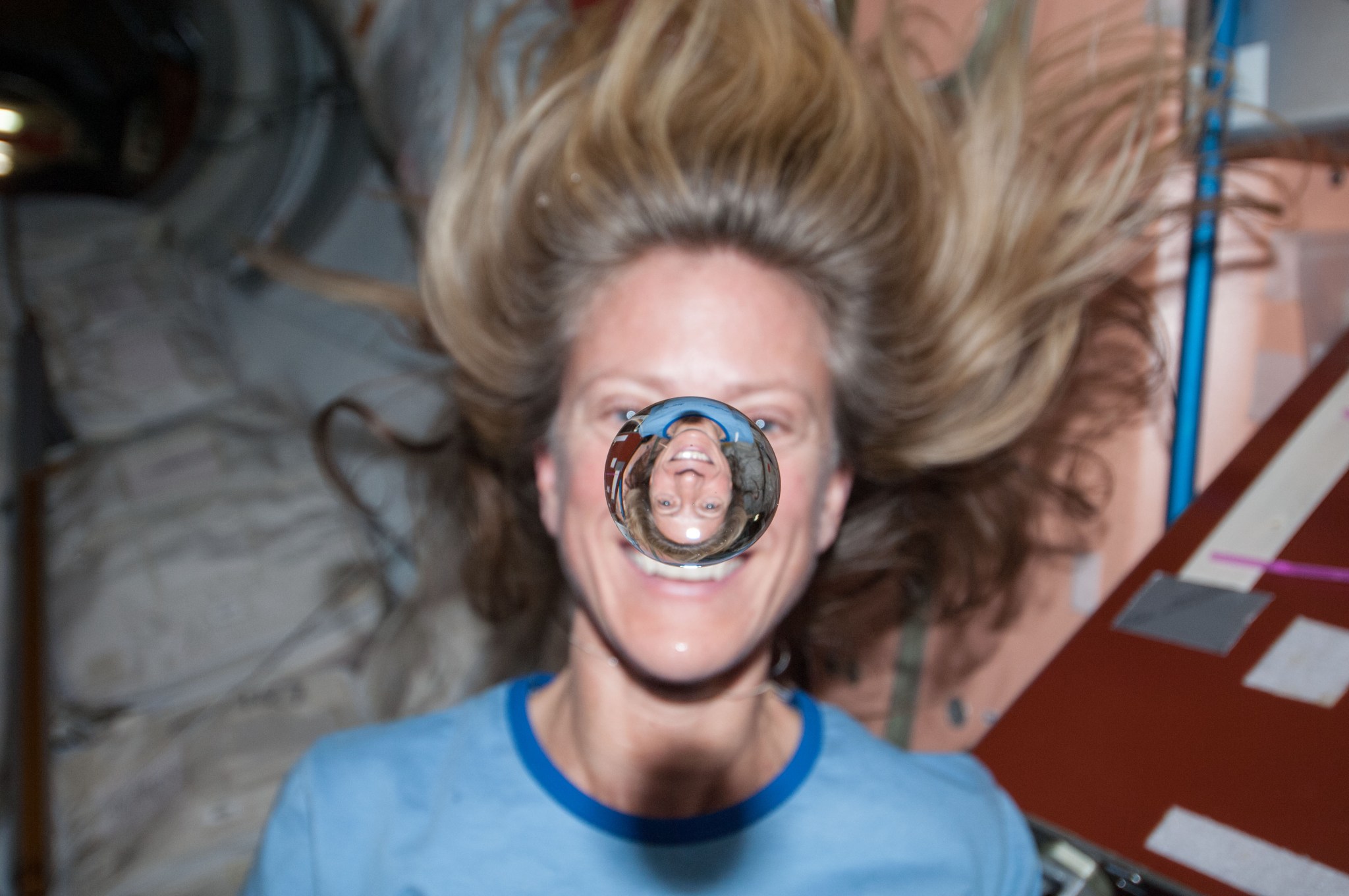 NASA astronaut Karen Nyberg watches a water bubble float freely between her and the camera.