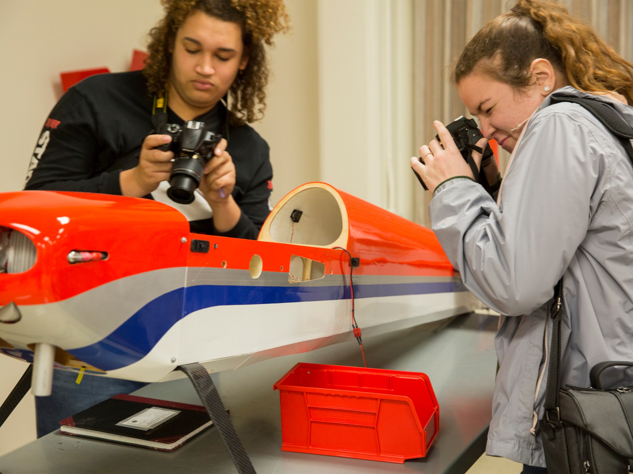 Green Run Collegiate High School students photograph a model aircraft at the hangar of NASA Langley.